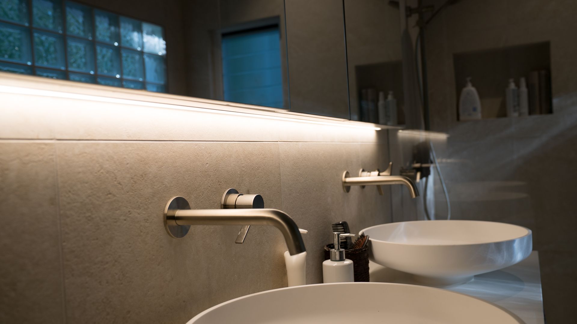 Modern Bathroom with Double White Vessel Sinks and A Glowing Backlit Mirror — Ralph Ottmann Electrical in Noosa, QLD