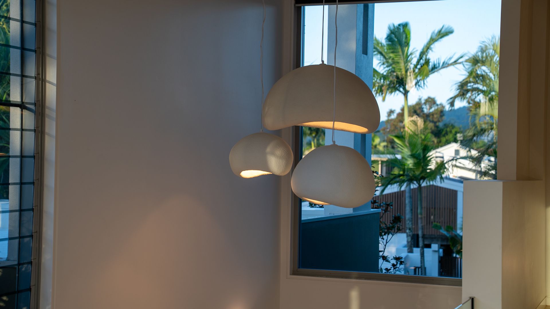 Modern Pendant Lamps by A Sunlit Window with Palm Trees Outside — Ralph Ottmann Electrical in Cooroy, QLD