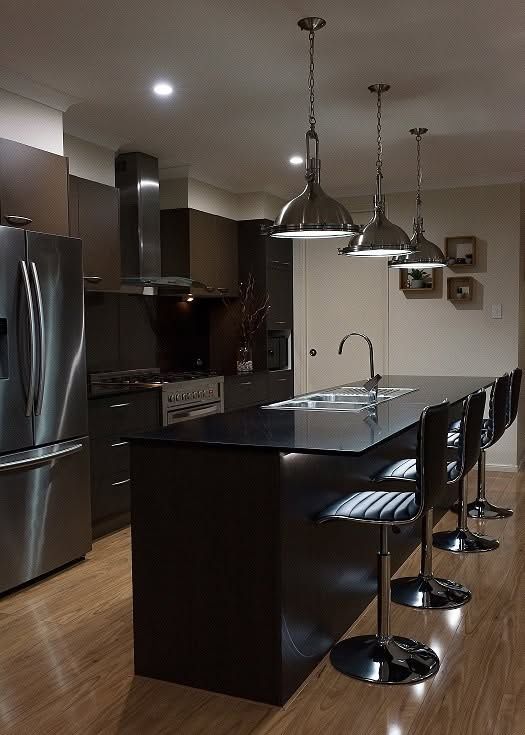 Modern Kitchen with Dark Cabinets, Black Island and Pendant Lights — Ralph Ottmann Electrical in Tewantin, QLD