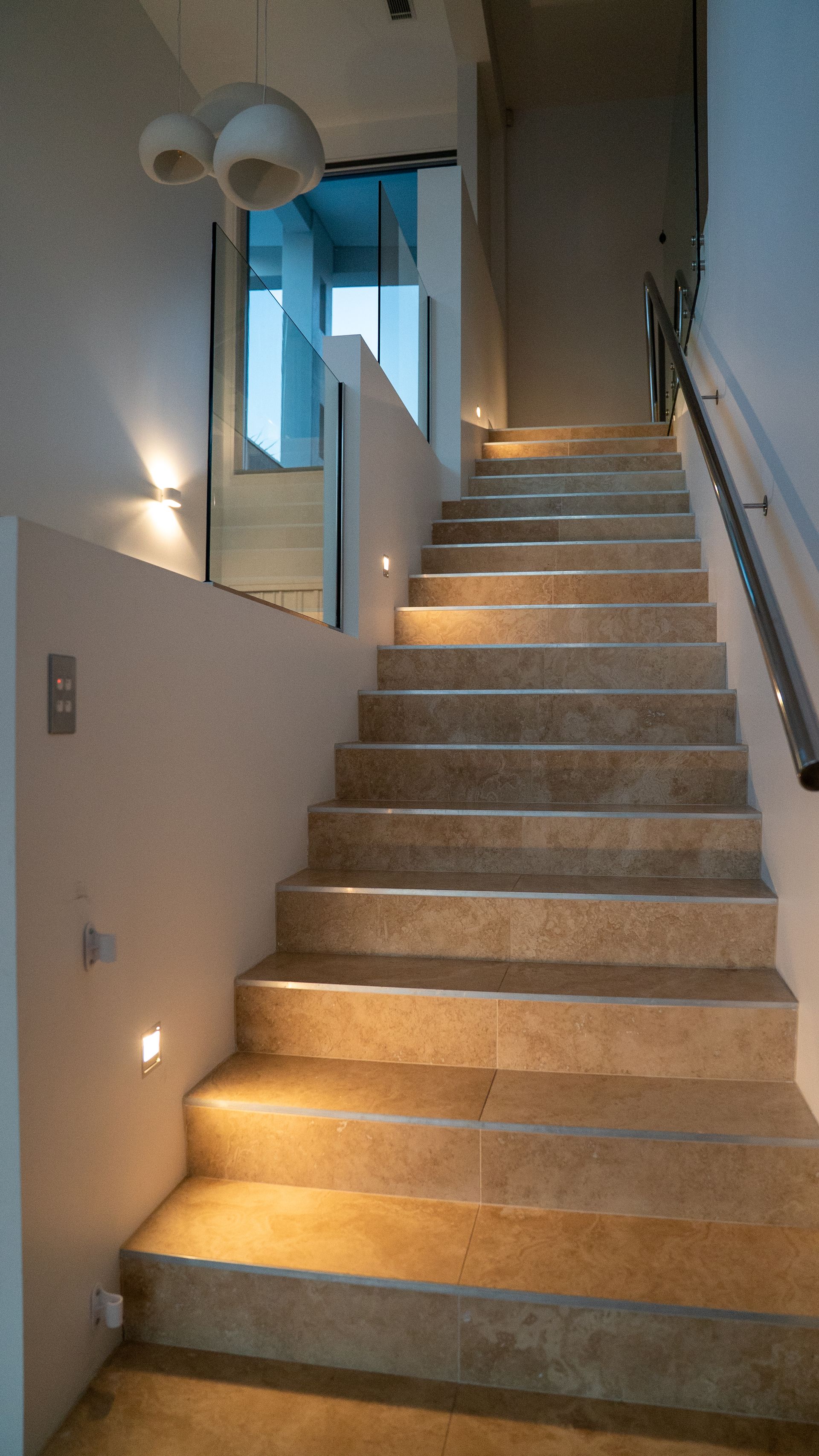 Indoor Carpeted Staircase with Wall Handrails and A Light Fixture, Lit by Warm Light from Below — Ralph Ottmann Electrical in Pomona, QLD