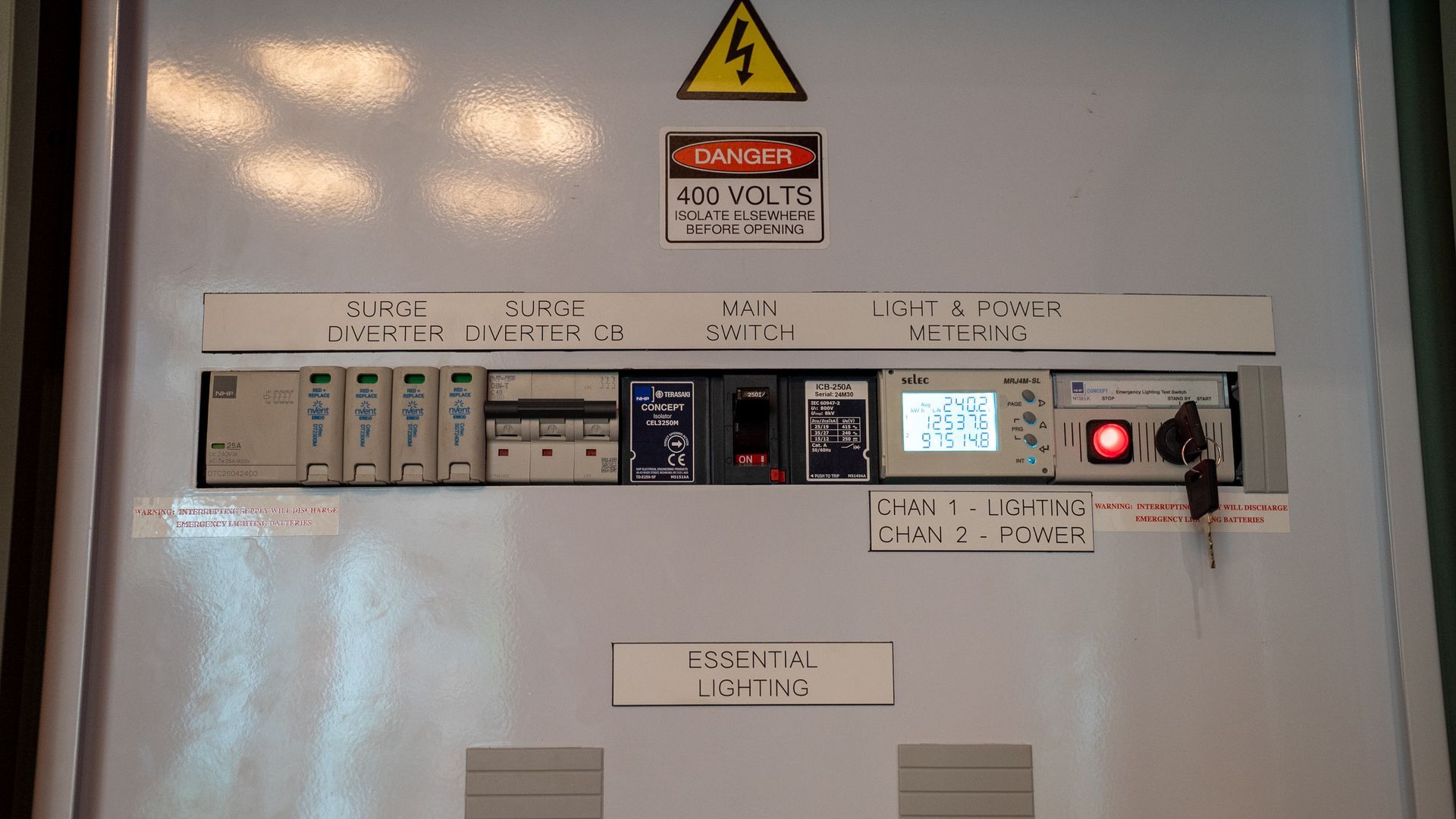 Electrical Control Panel With Warning Sign and Lit Display in a Utility Room — Ralph Ottmann Electrical in Tewantin, QLD