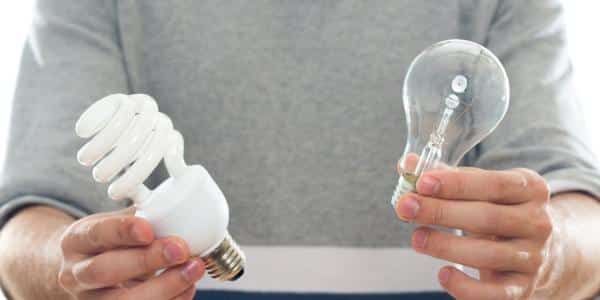 Person Holding a Fluorescent Light Bulb in One Hand — Ralph Ottmann Electrical in Pomona, QLD