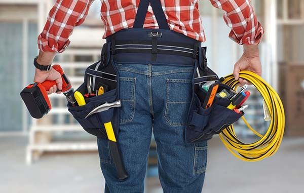 Handyman From Behind Wearing Tool Belt With Drills — Ralph Ottmann Electrical in Pomona, QLD
