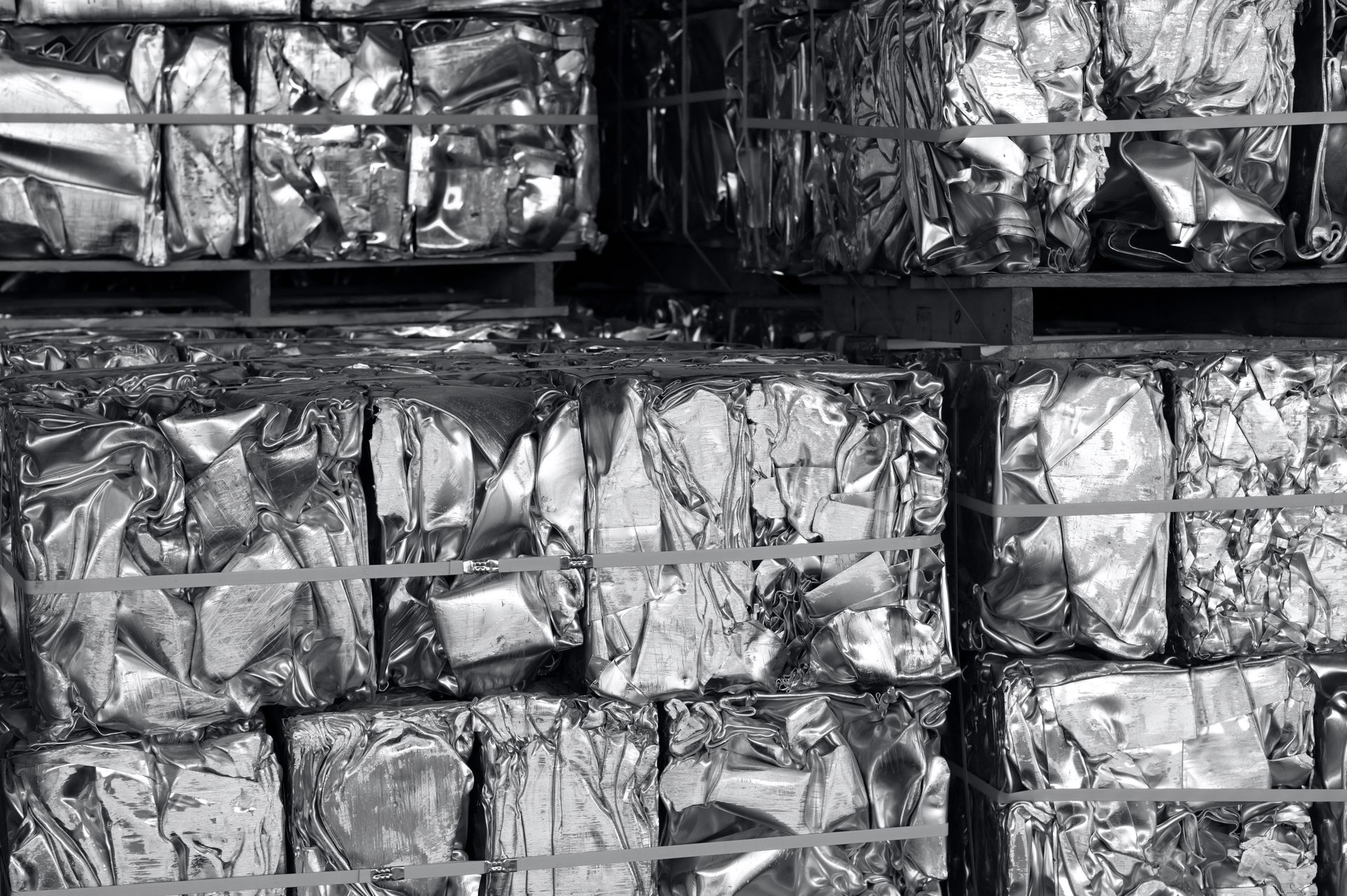 Stacked bundles of crumpled aluminum foil or metal sheets in a storage rack