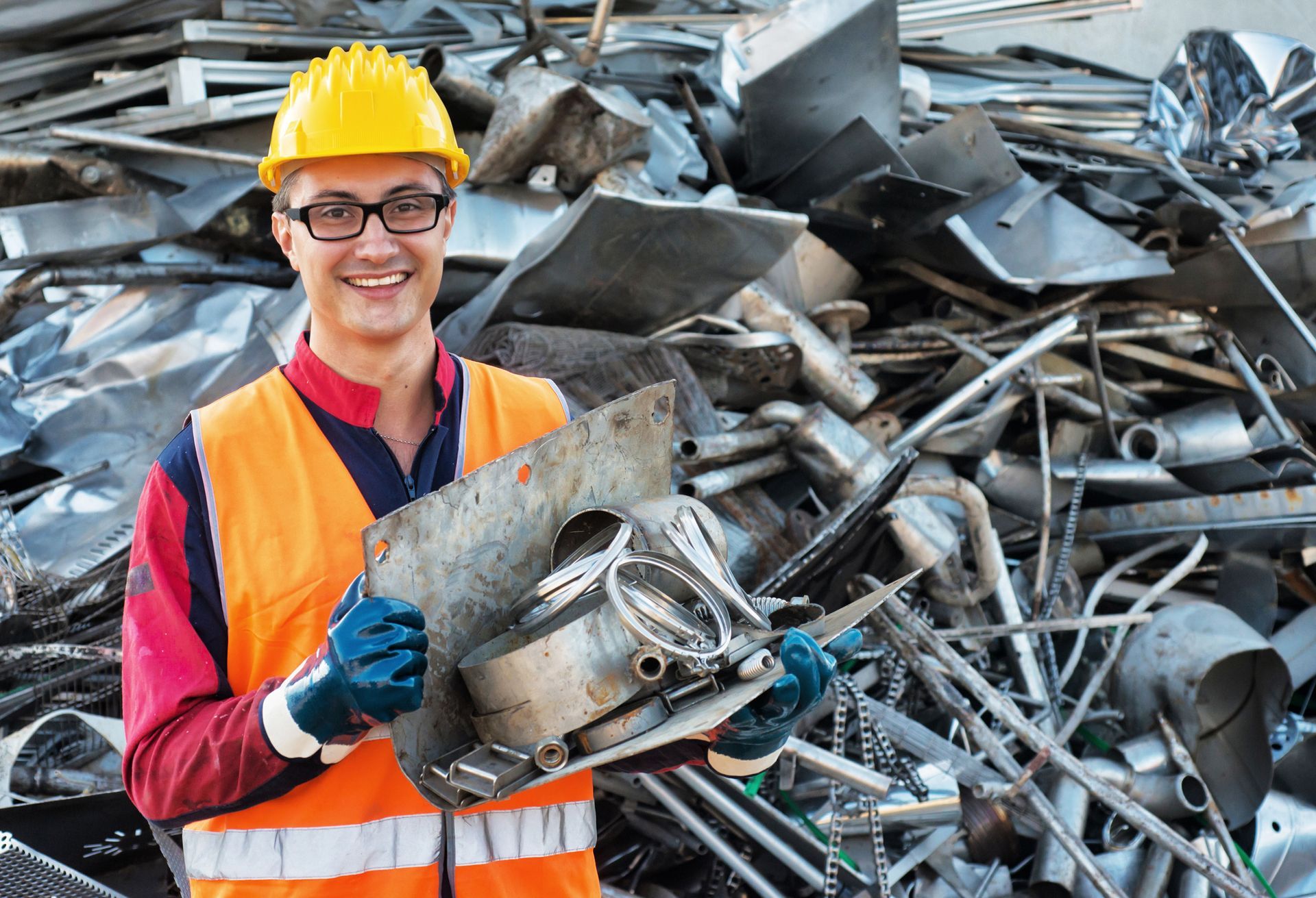 Man smiling with scrap metal, showcasing non-ferrous scrap metal recycling in Paterson, NJ