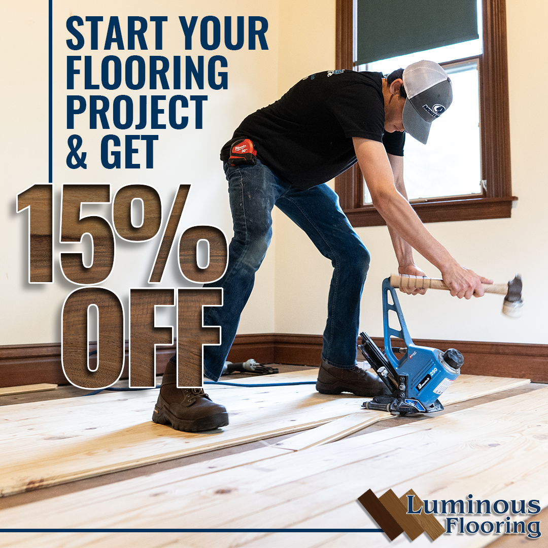 A man is working on a wooden floor with a hammer.