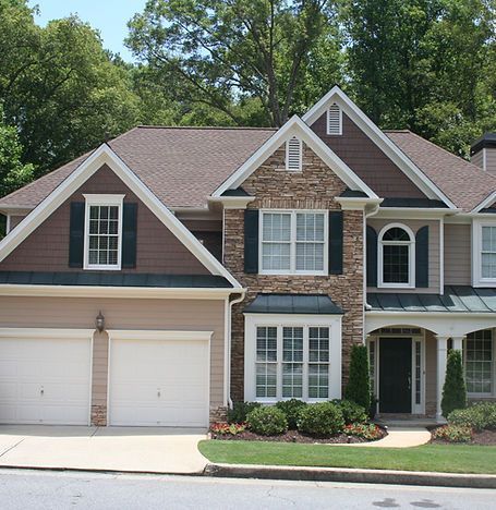 Suburban two-story house with brick and siding, double garage, and landscaped front yard