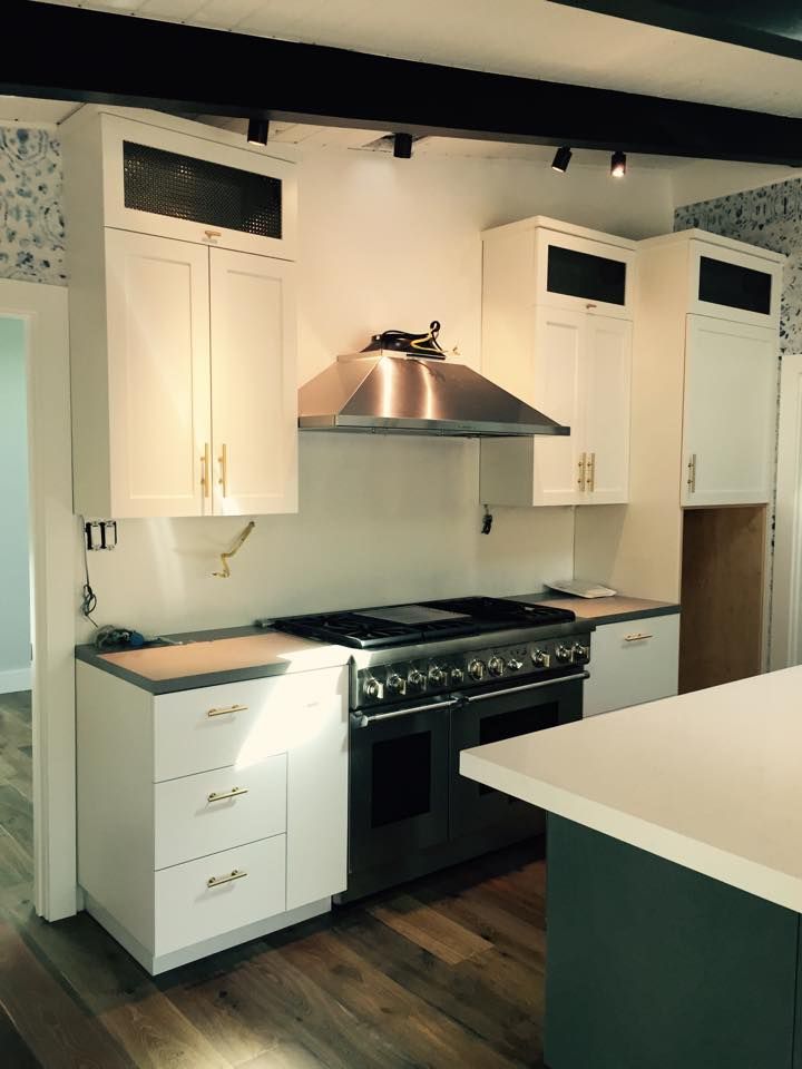 A kitchen with stainless steel appliances and white cabinets