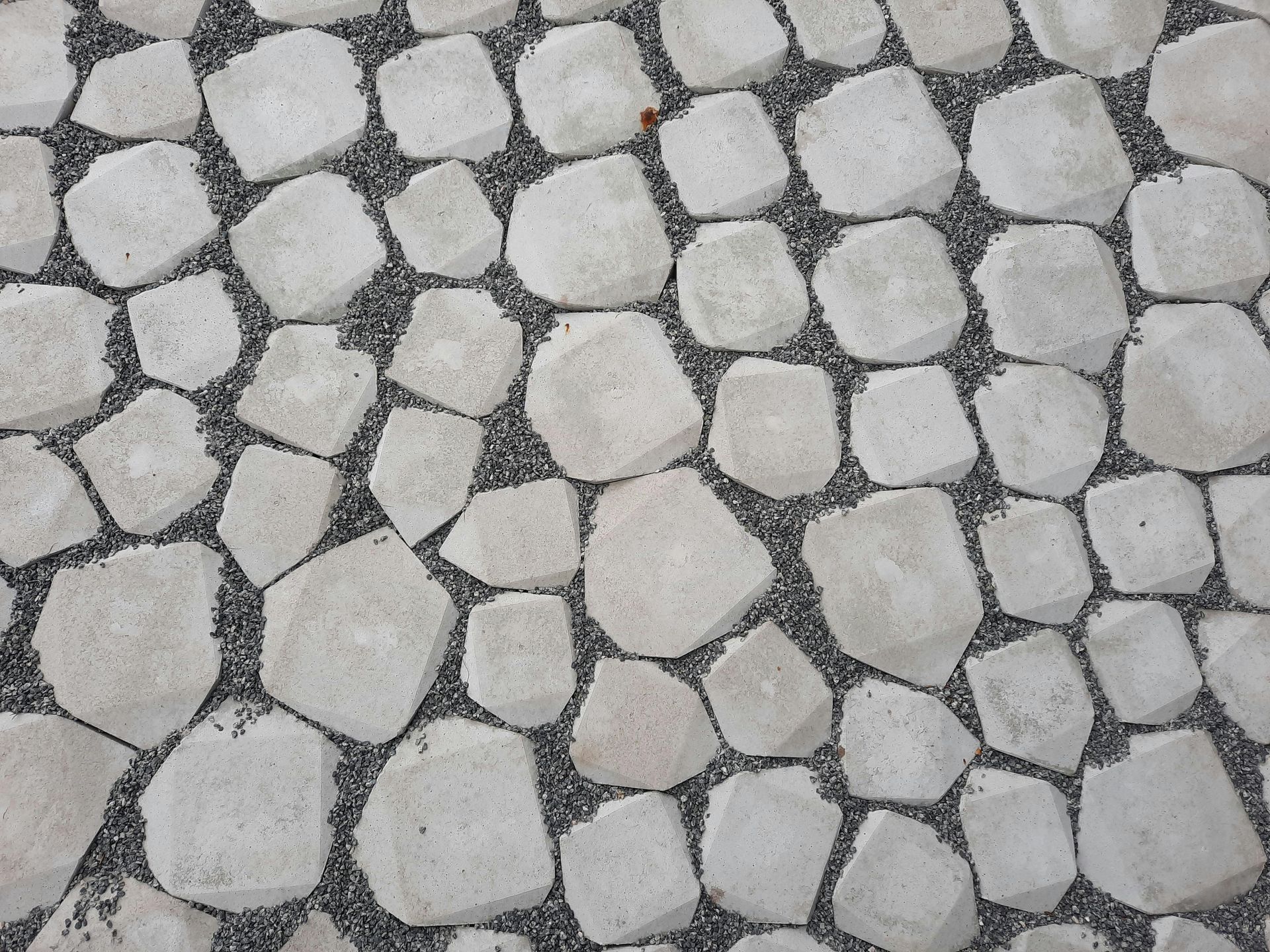 Close-up of light gray and beige cobblestone paving stones in an irregular pattern