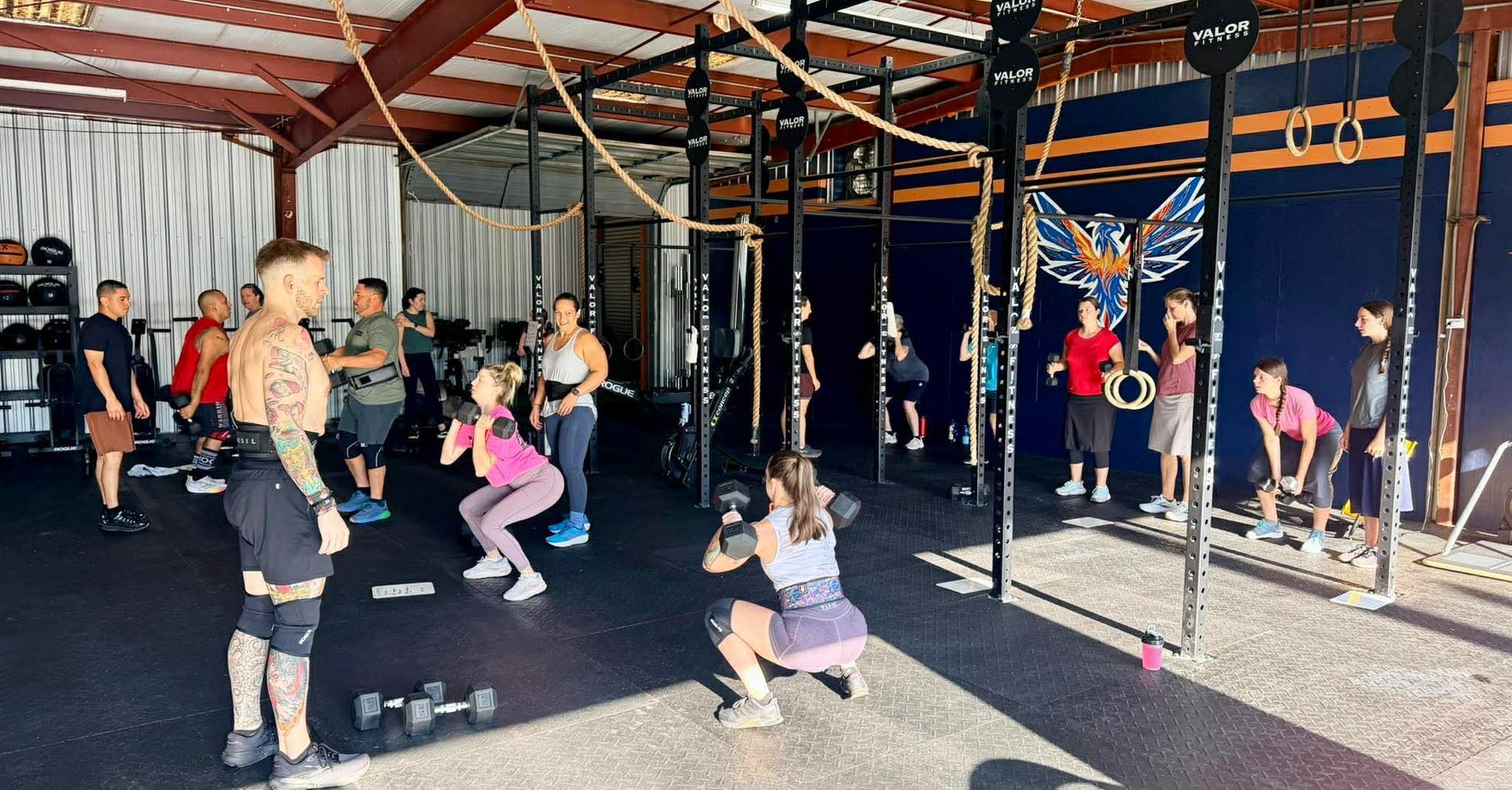 A fitness class in a gym where a group of people exercise under the guidance of an instructor.
