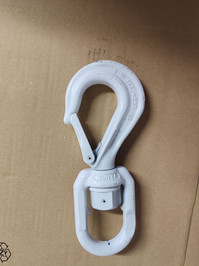 Mousqueton en métal blanc sur une surface beige