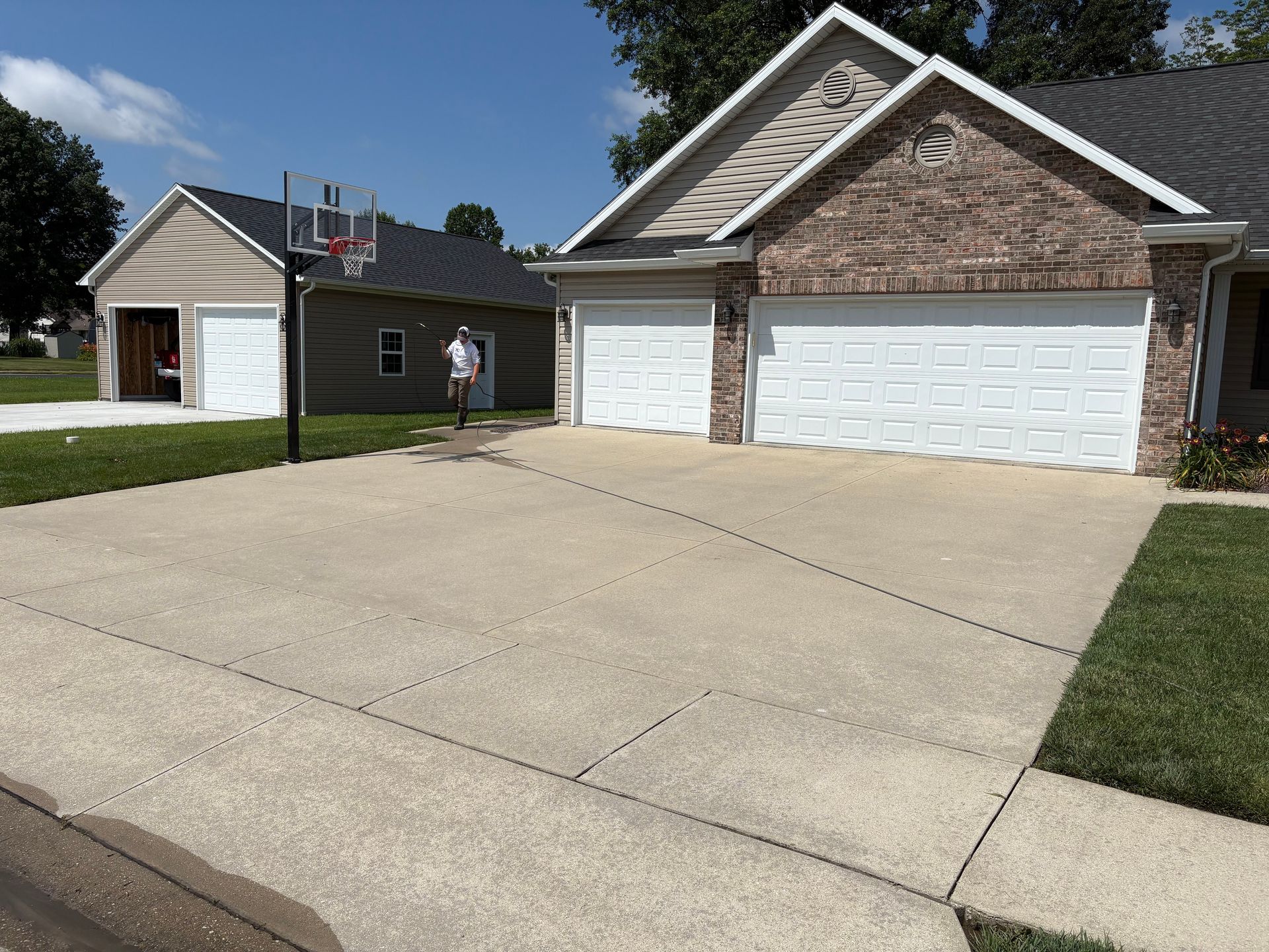 Suburban house with three-car garage and a basketball hoop beside a driveway