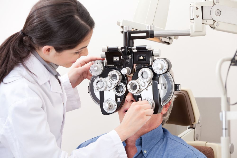 Optometrist Using a Phoropter to Examine a Patient's Eyes in a Clinic — EyeMax EyeCare in Newcastle, NSW