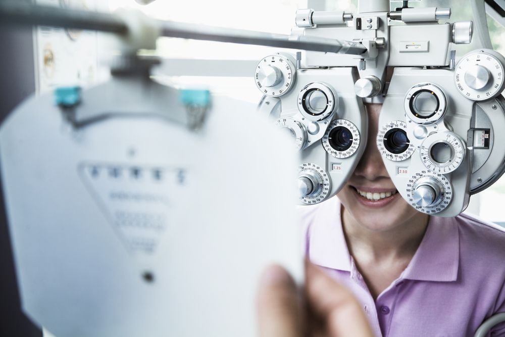 Person Undergoing an Eye Exam Using a Phoropter — EyeMax EyeCare in Wallsend, NSW
