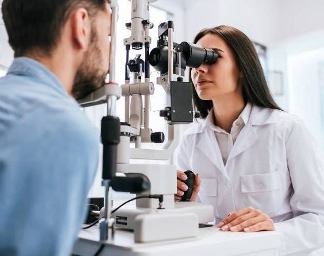 Optometrist Examining a Patient's Eyes With a Slit Lamp in a Doctor's Office — EyeMax EyeCare in Wallsend, NSW