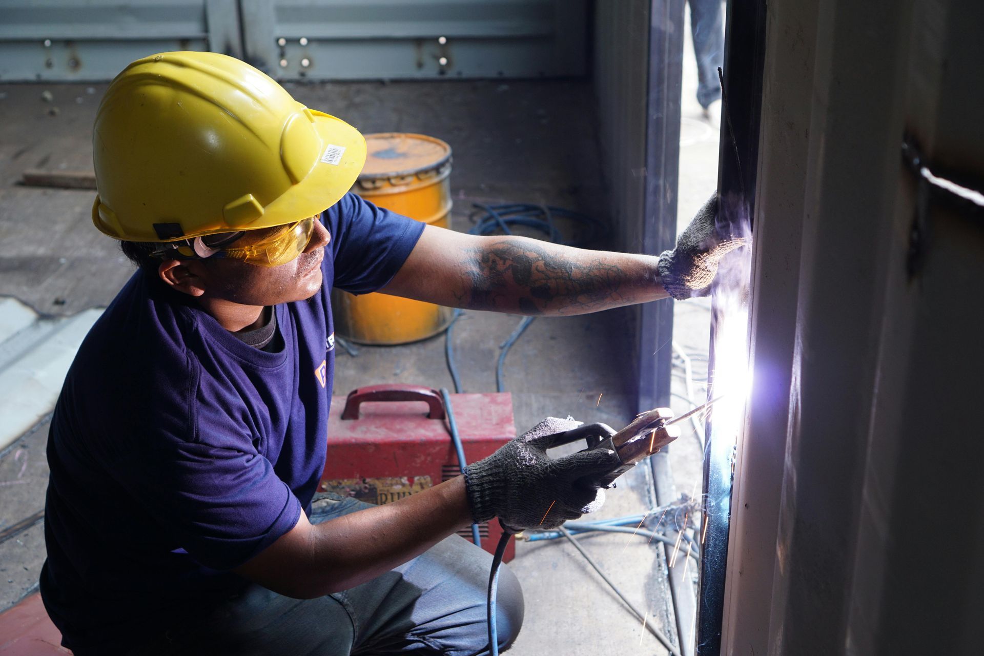 Person in a Yellow Hard Hat Welds Metal Inside a Structure — EyeMax EyeCare in Maitland, NSW