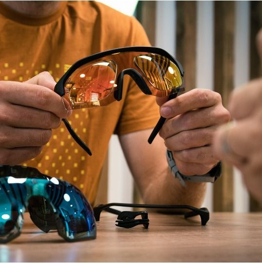 Person Holding Up Orange-lensed Sunglasses — EyeMax EyeCare in Singleton, NSW
