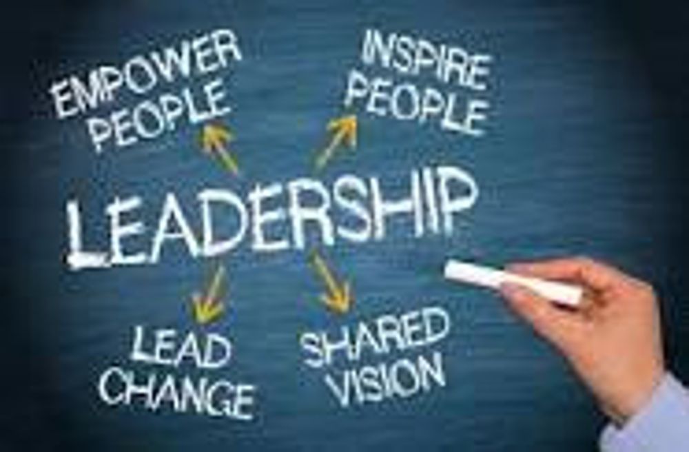 A person is writing the word leadership on a blackboard.