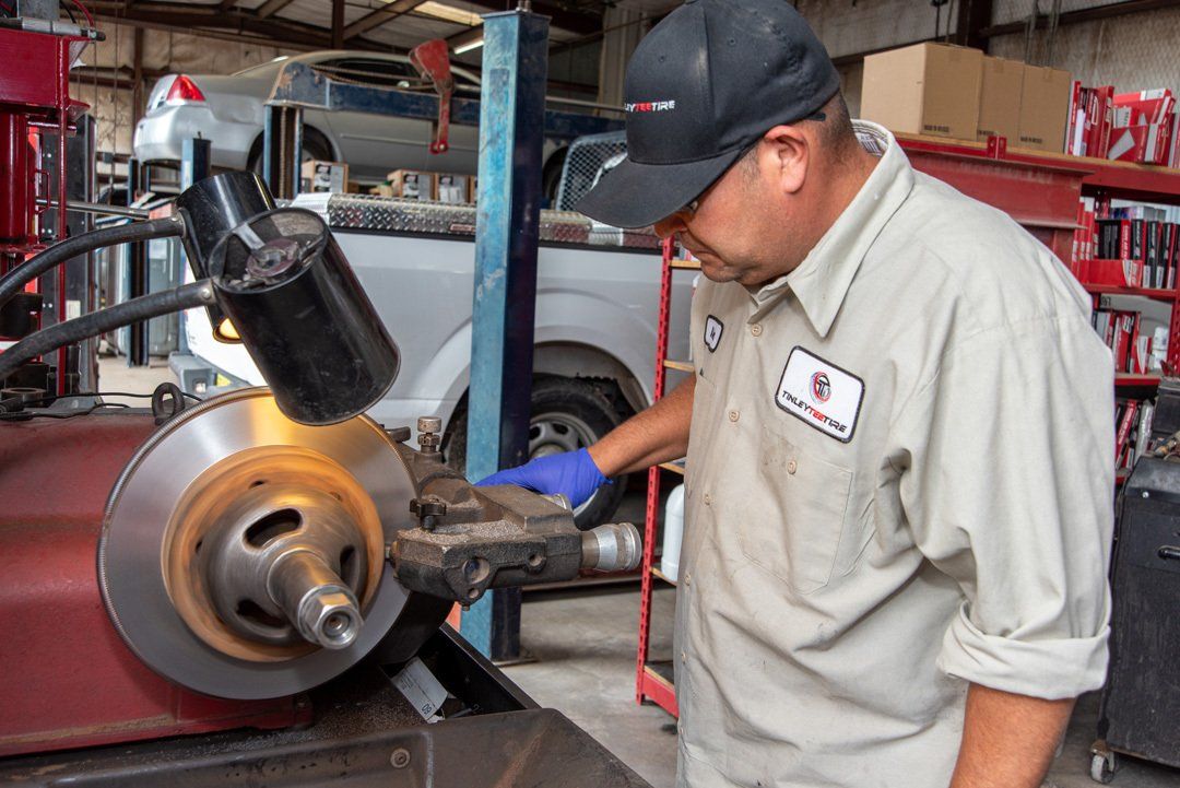Mechanic inspecting a car brake rotor in an auto repair shop