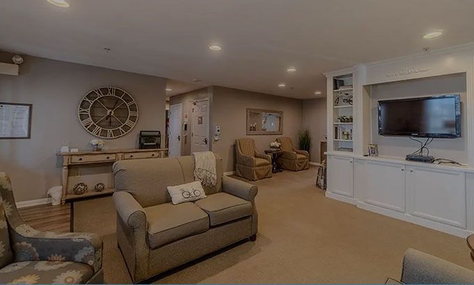 Cozy living room with beige sofa, wall clock, TV, and white built-in cabinets