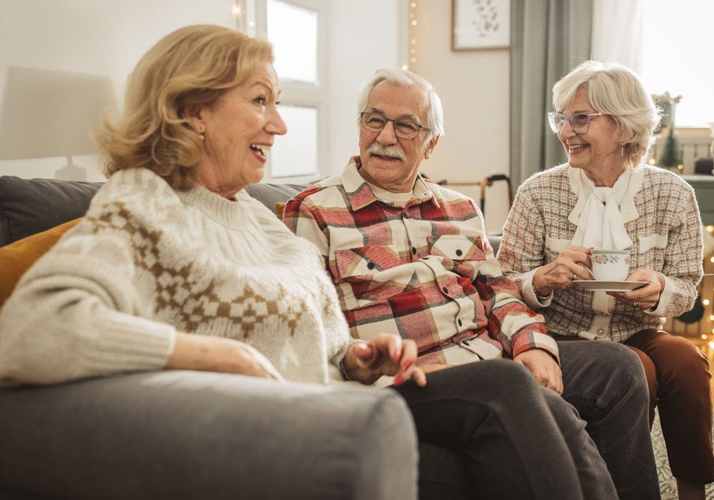Three people chatting on a couch in a cozy living room