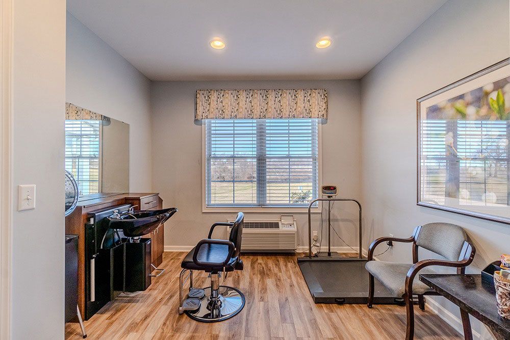 Bright home salon with chairs, styling sink, and large window overlooking a snowy view.