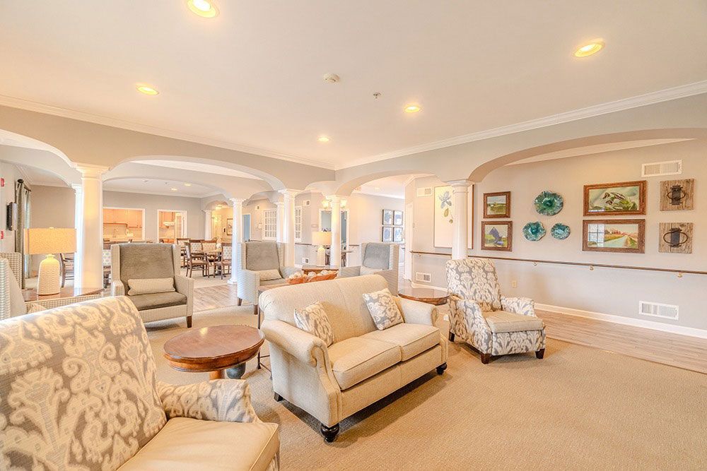 Bright beige living room with floral chairs, cream sofa, and wall art in a spacious open layout