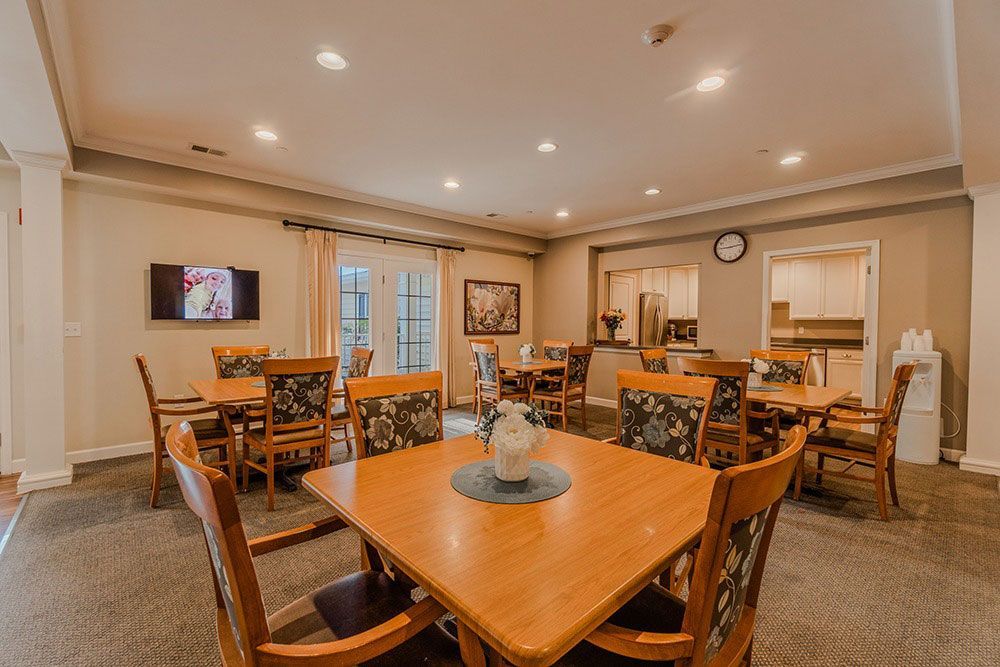 Elegant dining room with wooden tables, chairs, and warm recessed lighting