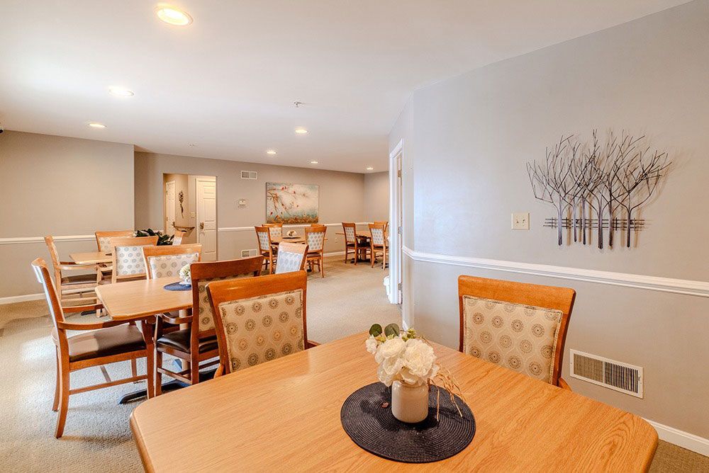 Dining room with wooden tables and chairs in a bright, neutral-toned interior