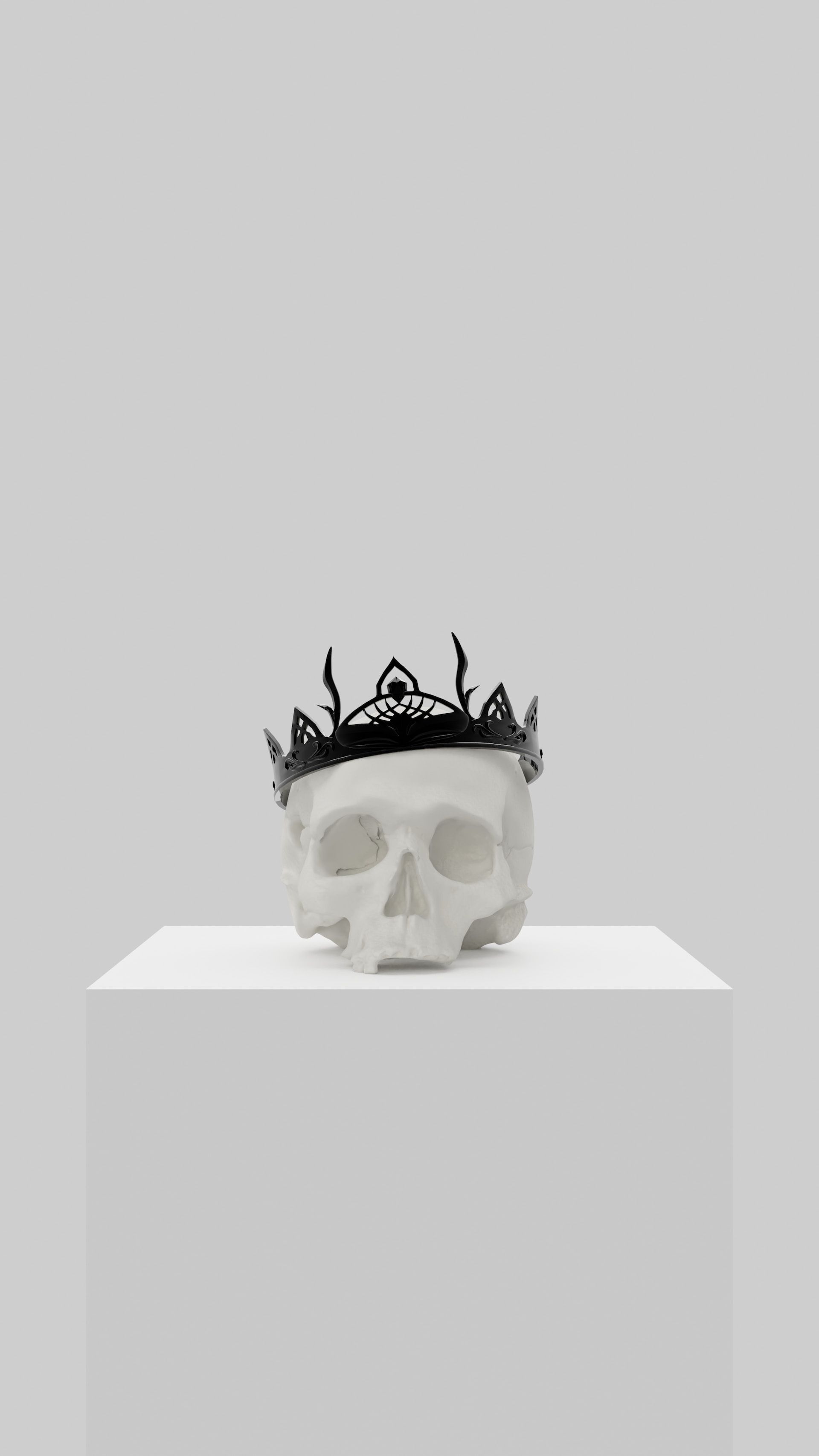 White skull sculpture wearing a black leafy crown on a white pedestal against a gray background