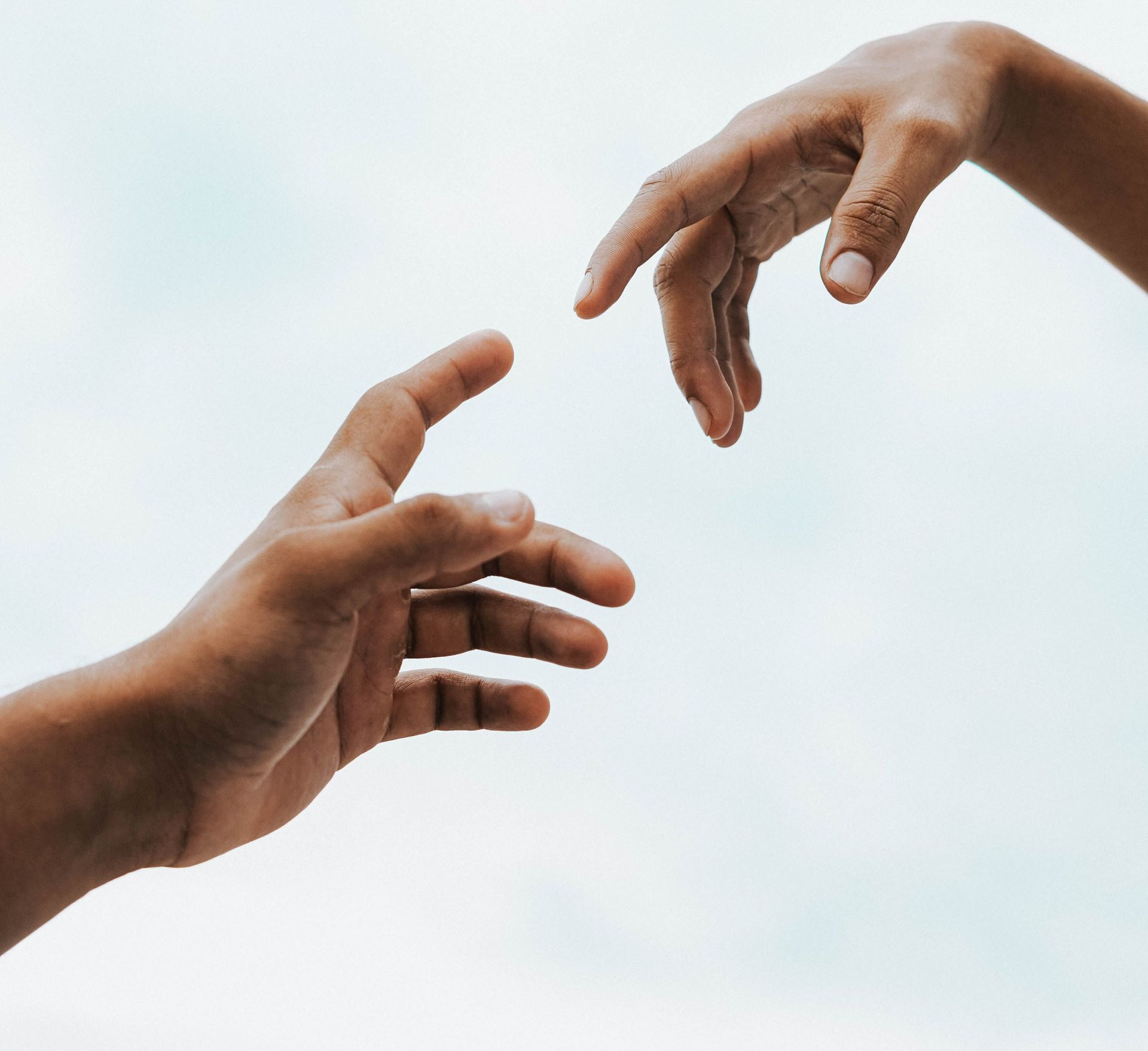 Two hands reaching toward each other against a white background