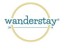 Logo for Wanderstay with teal text inside a gold double circle.