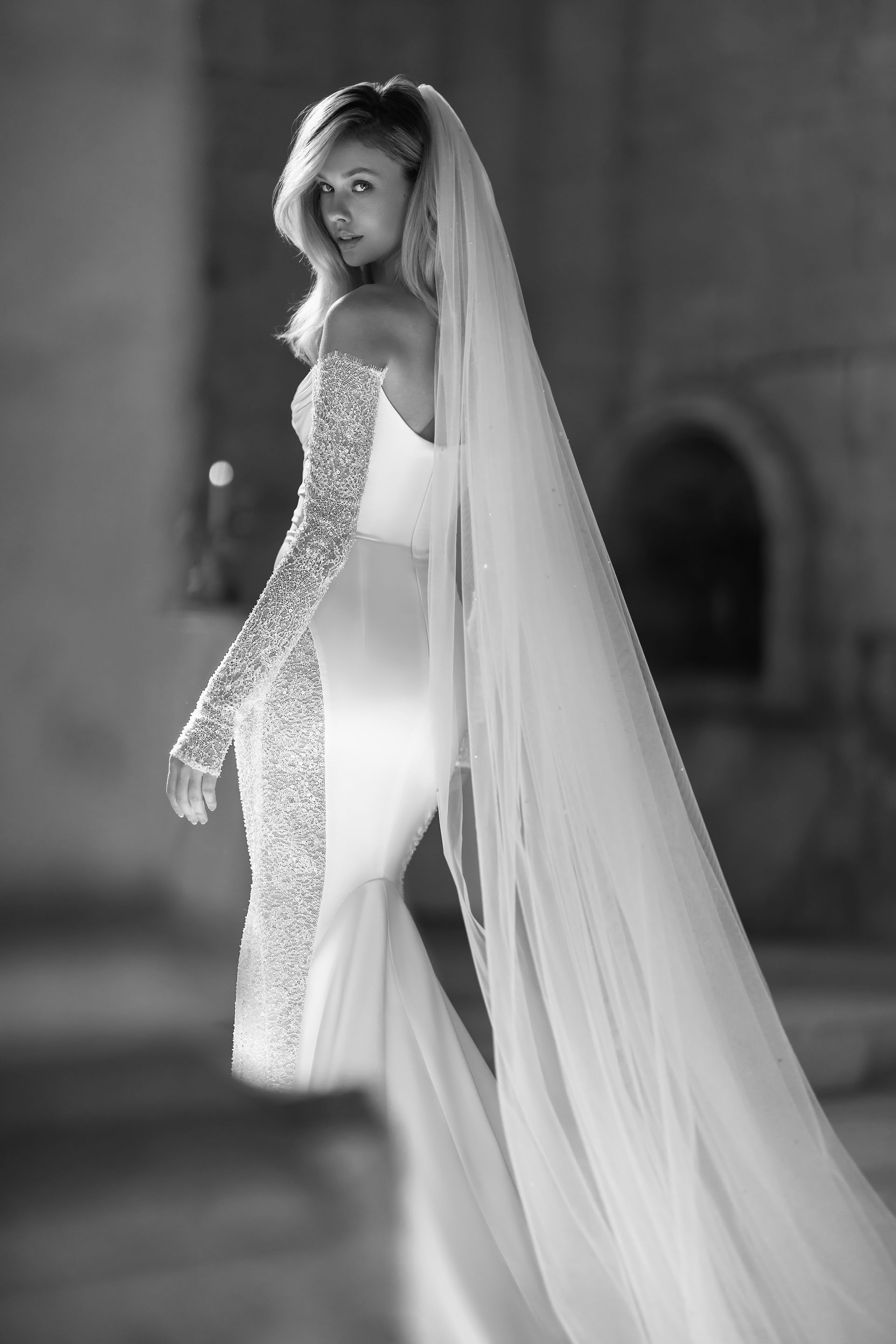 A black and white photo of a woman in a wedding dress and veil.