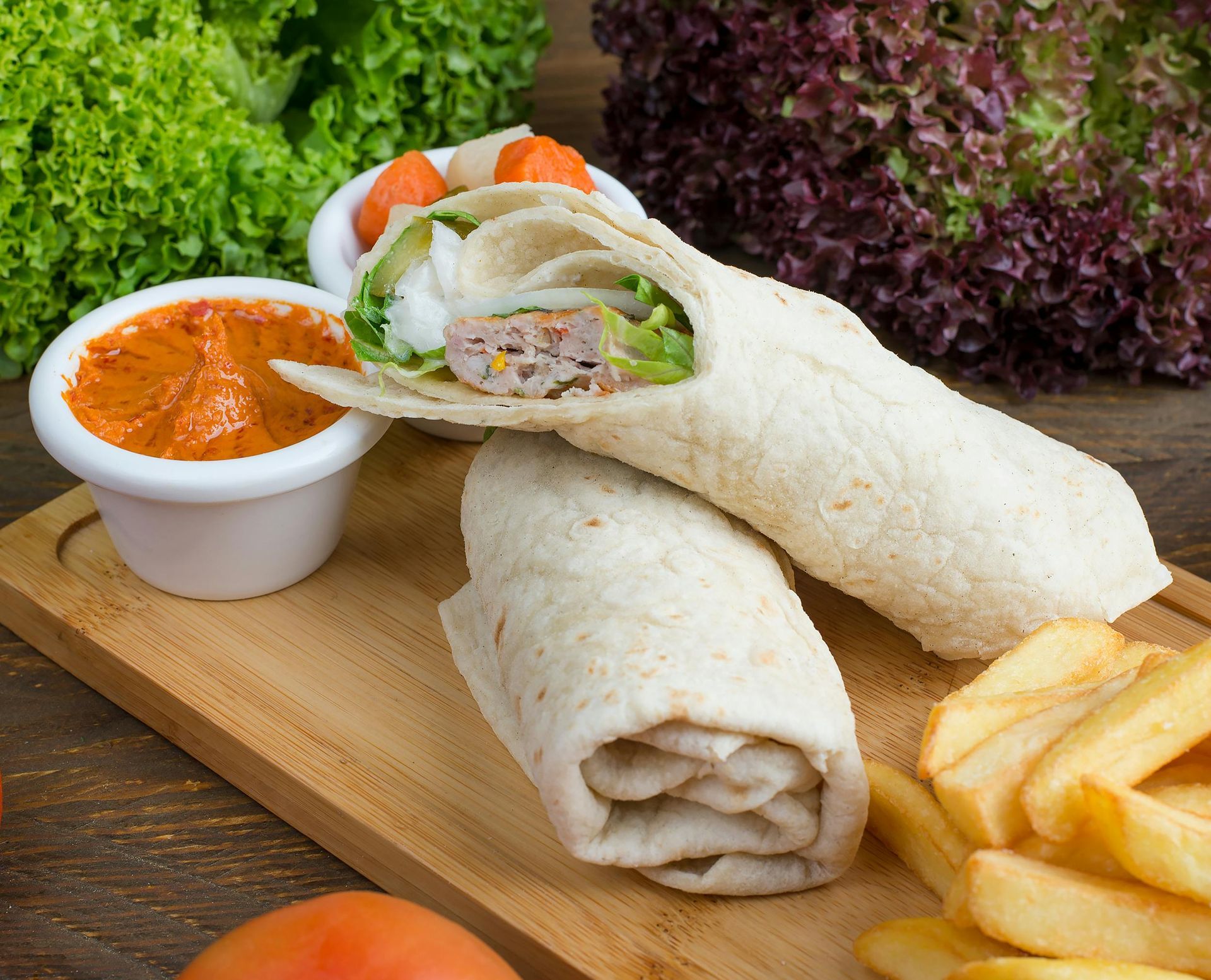 Wrap sandwich with side of fries, sauce, and lettuce.