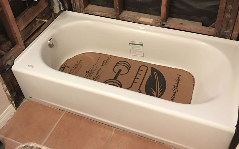a bathtub with a cardboard mat that says american standard on it
