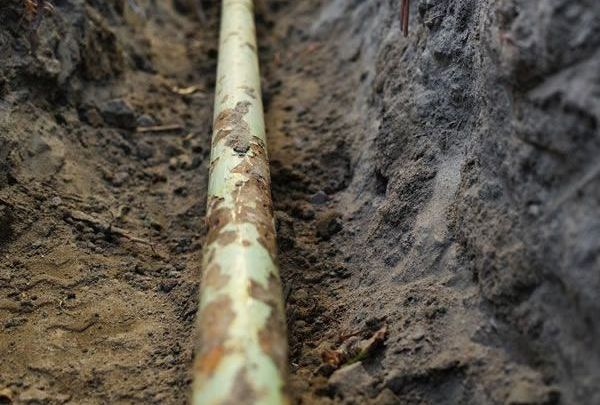 a pipe is laying in the dirt in a trench .