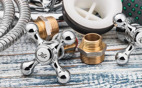 a bunch of plumbing parts are sitting on a wooden table .