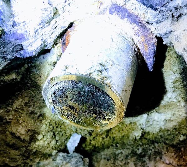 a close up of a rusty pipe in the ground