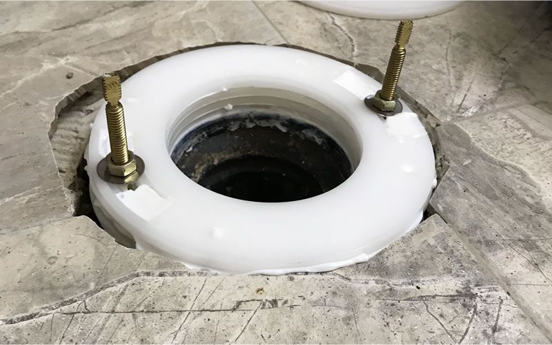 a hole in the floor with a white ring on top of it