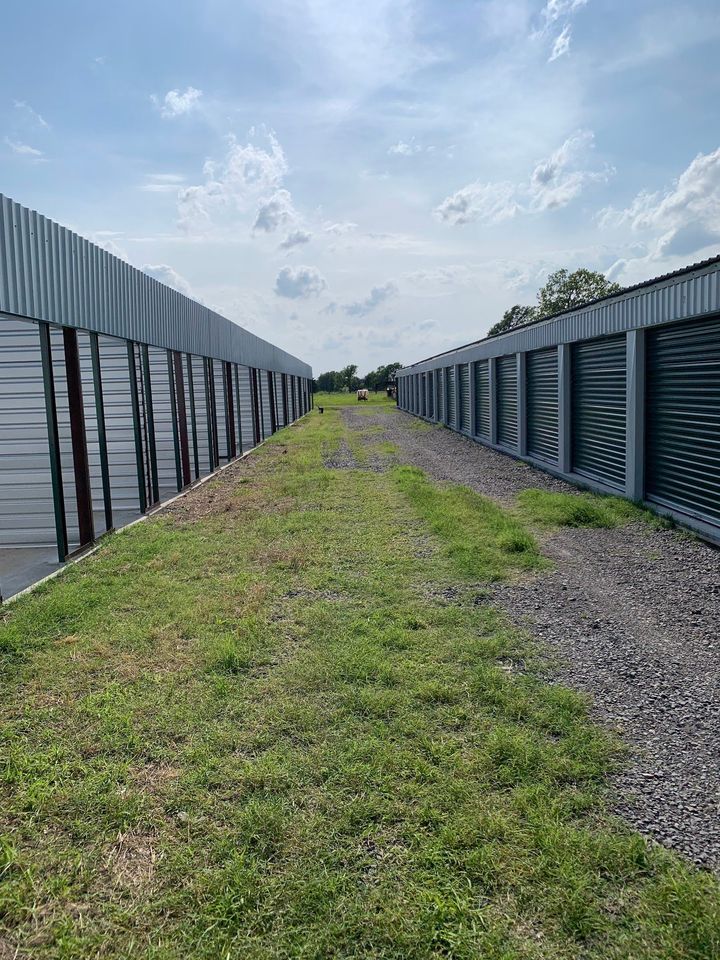 Gravel path between metal storage units under a cloudy sky