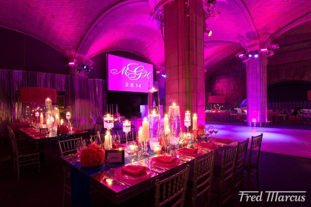 A large room with purple lights and tables and chairs