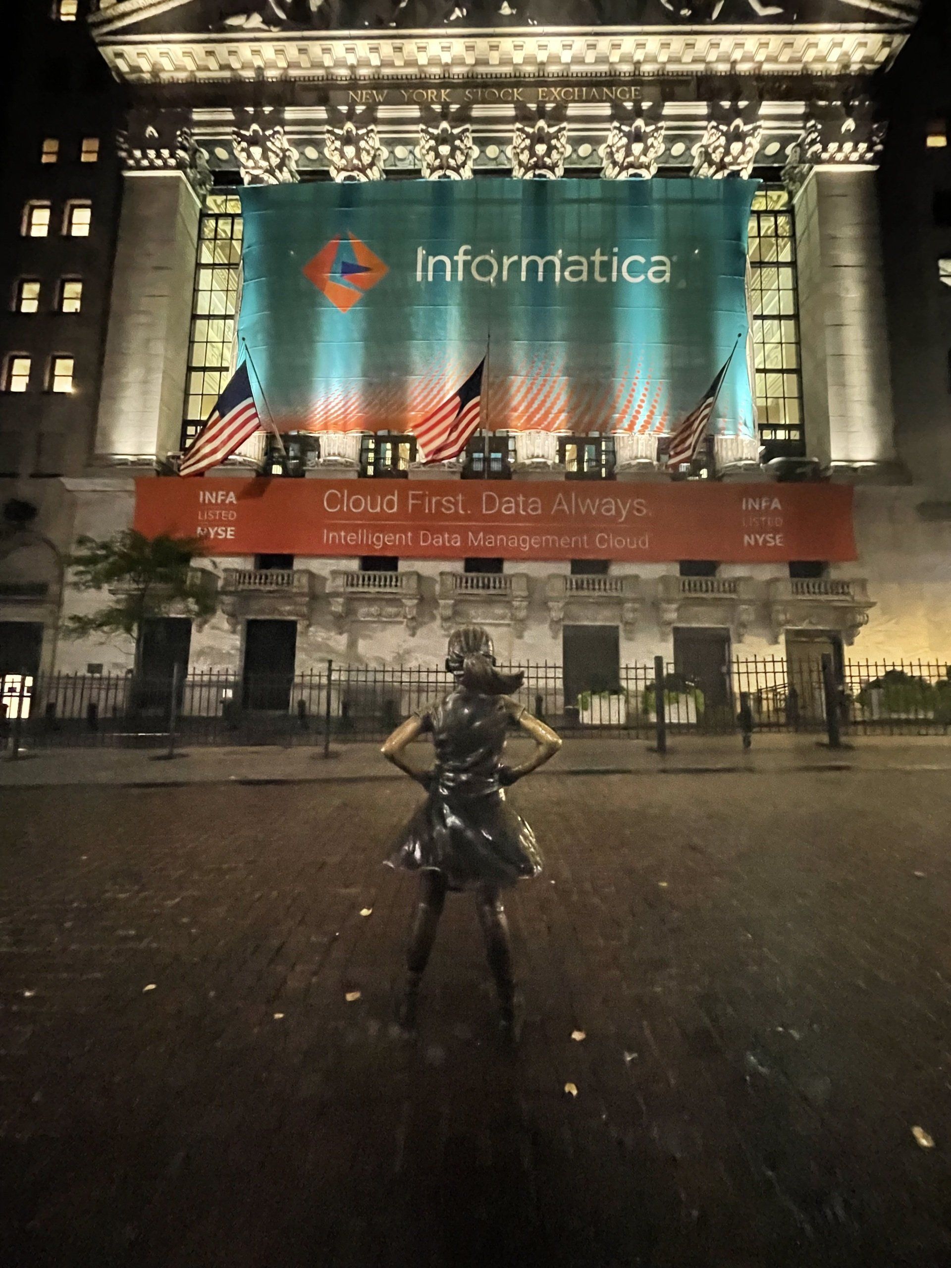 A woman stands in front of a large informatica sign