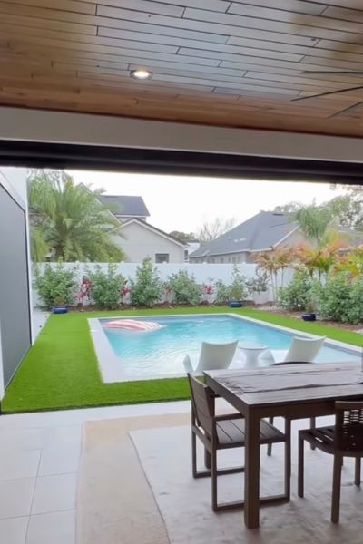 Hay una gran piscina en el patio trasero de una casa.