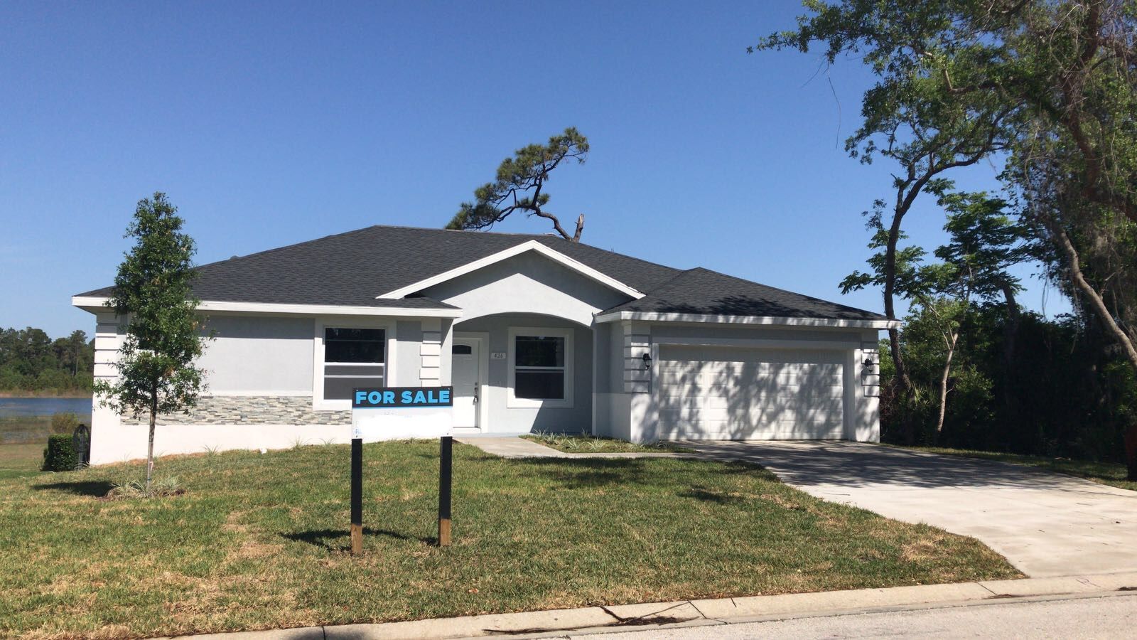 A white house with a for sale sign in front of it