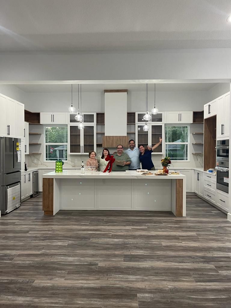 A group of people are posing for a picture in a kitchen.