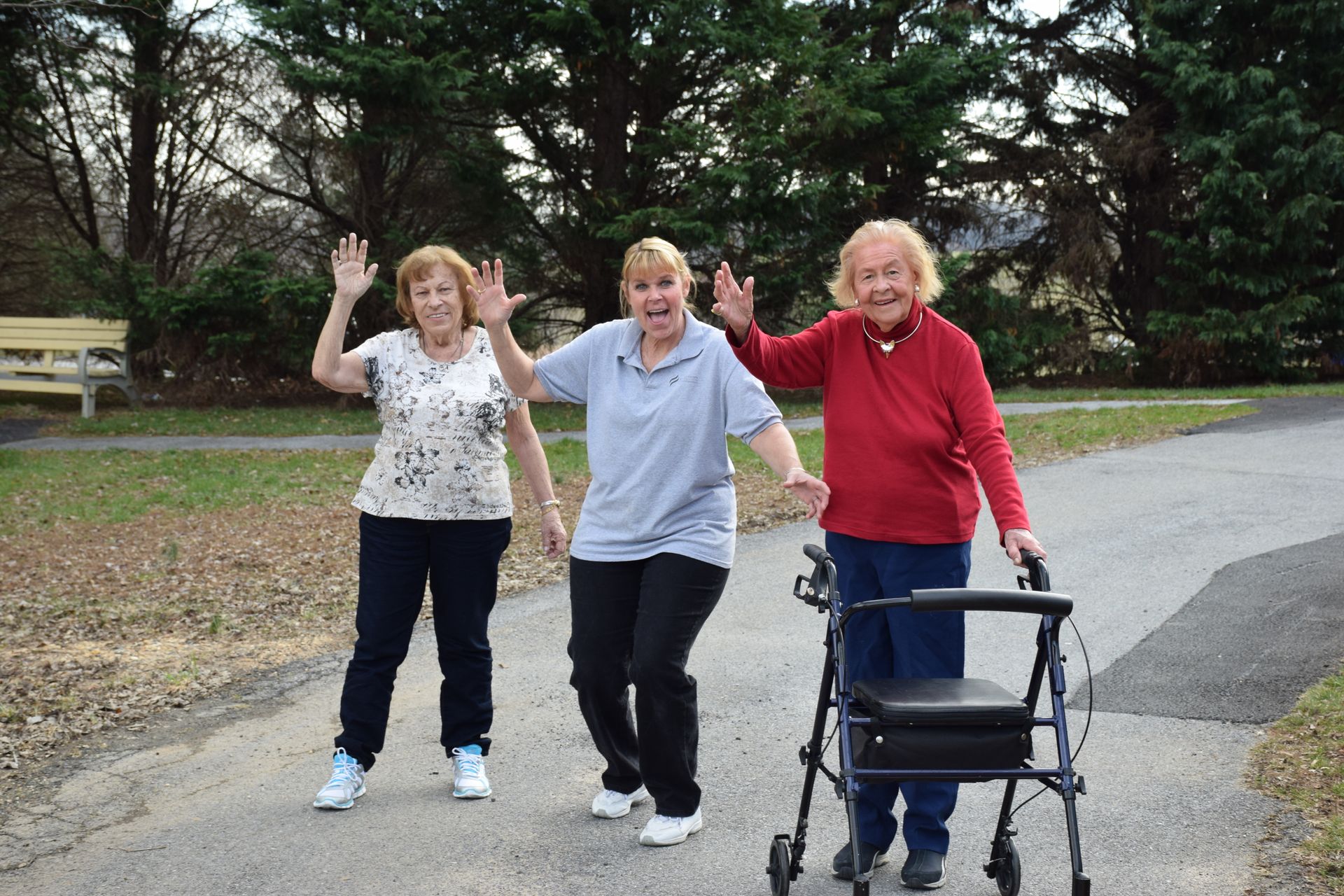 Hands of a caregiver gently holding an elderly person’s hand beside a wooden cane