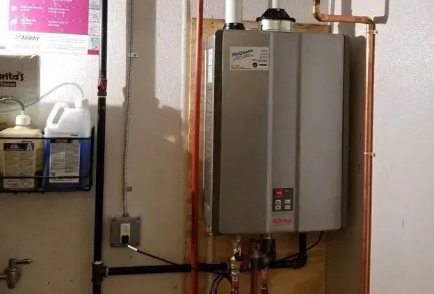 A water heater is sitting in a room next to a wall.