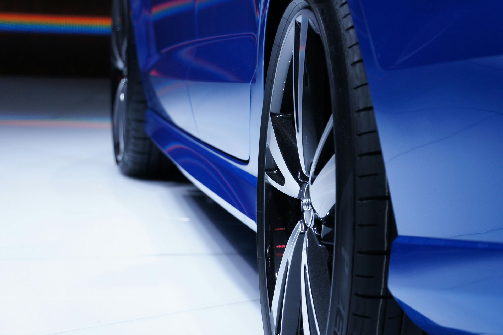 A close up of a blue car with black wheels