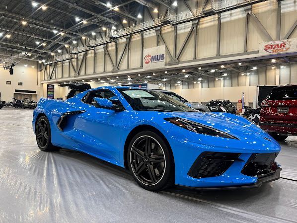 A blue sports car is parked in a showroom.