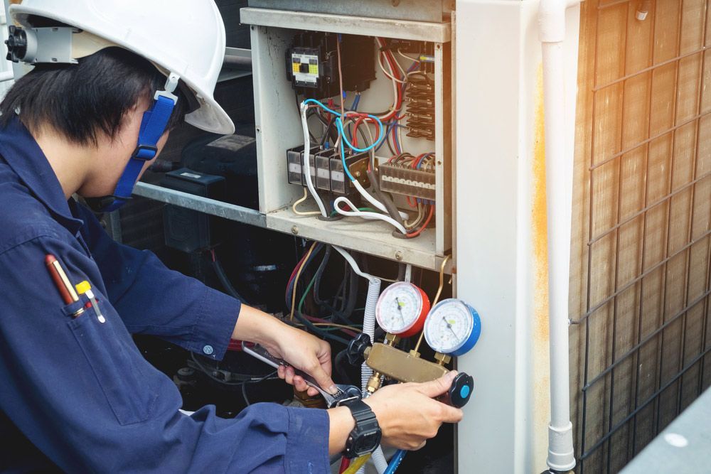 Technician Is Checking Air Conditioner — John B Electrical In Wodonga VIC